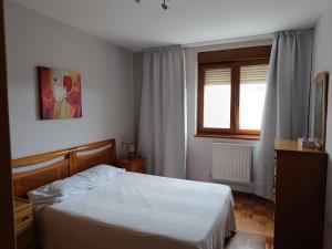 a bedroom with a white bed and a window at Casa Montse - Derecha in Colombres