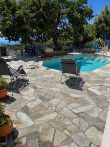 a patio with two chairs and a swimming pool at Ioannis Appartements Glossa in Glossa