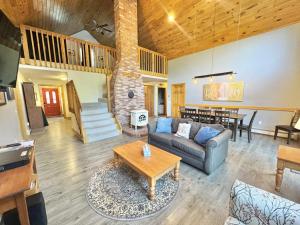 a living room with a couch and a table at Riverfront home w/ deck, amazing views & firepit - near the best of Maine in Stockton Springs