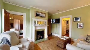 a living room with green walls and a fireplace at Commanders Cabin, quaint apt steps to downtown in Camden