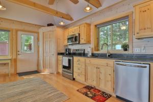 a large kitchen with wooden cabinets and a sink at Luxe Bayfront Cabin w/ Stunning Views & Shared Dock- Ideal for Hunting & Fishing in Bowdoinham