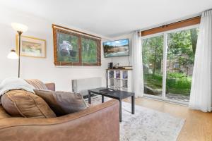 a living room with a couch and a table at Two-Level Unit w/ Patio, Deck, Firepit, Private Washer/ Dryer, and Free WiFi in Seal Harbor