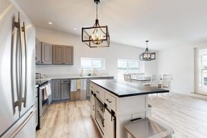 a kitchen with a refrigerator and a counter top at Elegant Oceanfront Condo with Stunning Harbor Views & Spectacular Sunsets in Boothbay Harbor