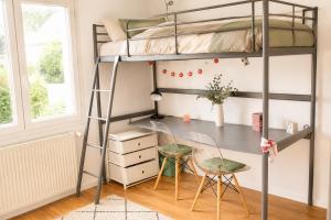 a bedroom with a bunk bed and a desk and chairs at Le Forest - Saint-Cyr-l'École in Saint-Cyr-lʼÉcole