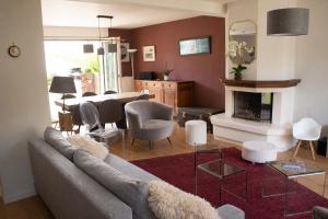 a living room with a couch and a fireplace at Le Forest - Saint-Cyr-l'École in Saint-Cyr-lʼÉcole