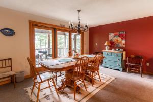 a dining room with a wooden table and chairs at Gorgeous lakefront home w/ dock, canoe, kayaks & lake/forest views in Ellsworth