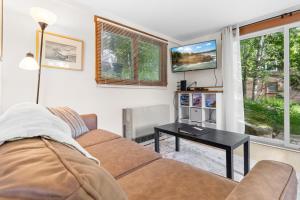 a living room with a couch and a table at Two-Level Unit w/ Patio, Deck, Firepit, Private Washer/ Dryer, and Free WiFi in Seal Harbor