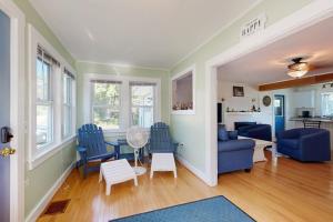 a living room with blue chairs and a table at Charming Cottage with Cozy Comfort and Easy Access to Outdoor Adventures in North Lamoine