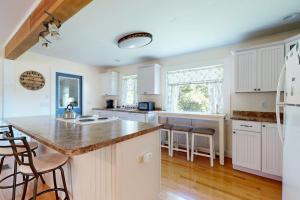 a kitchen with white cabinets and a large island at Charming Cottage with Cozy Comfort and Easy Access to Outdoor Adventures in North Lamoine +16 photos
