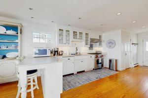 a kitchen with white cabinets and a counter top at Oceanfront home incredible ocean views, deck & location in Boothbay