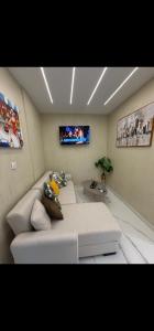 a living room with a white couch and a tv at Aggelos Room 4 in Volos