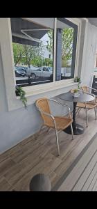 a patio with a table and chairs and a window at Aggelos Room 4 in Volos