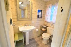 a bathroom with a sink and a toilet and a mirror at Berry Cottage, private dock, overlooking a sandy b in South Thomaston