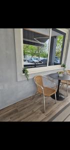 a room with a chair and a table and a window at Aggelos Room 4 in Volos