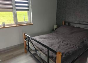 a bedroom with a bed and a window at Wakacyjne relaksacyjnie in Szczytno
