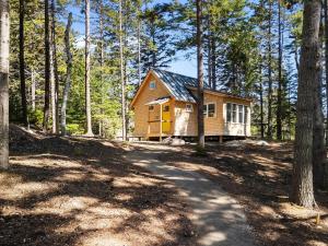 a cabin in the woods with a dirt road at Lindquist Cottage | Waterfront Studio with King Bed in Clark Island