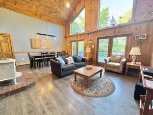 a living room with a couch and a table at Riverfront home w/ deck, amazing views & firepit - near the best of Maine in Stockton Springs