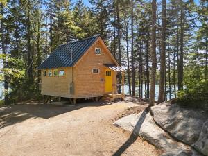 a tiny house on a hill in the woods at Lindquist Cottage | Waterfront Studio with King Bed in Clark Island +22 photos