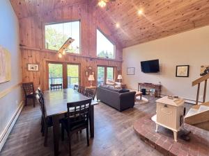 a dining room and living room with a wooden ceiling at Riverfront home w/ deck, amazing views & firepit - near the best of Maine in Stockton Springs