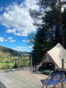 a tent with a table and chairs on a deck at Glamping-Dimbo in Krynica Zdrój