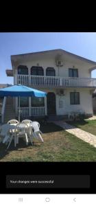 a house with chairs and umbrellas in front of it at Esko Rooms in Donji Štoj