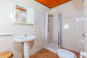 a bathroom with a shower and a toilet and a sink at L'Agrumeto domos in Teulada +31 photos