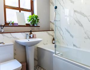 a bathroom with a sink and a tub and a toilet at Spacious One-Bed Apartment in Chester in Chester