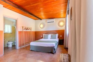 a bedroom with a bed and a bathroom at L'Agrumeto domos in Teulada