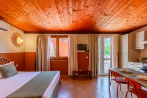 a bedroom with a bed and a table with chairs at L'Agrumeto domos in Teulada