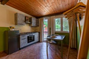 a kitchen with a stove and a table in it at L'Agrumeto domos in Teulada