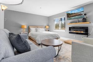 a living room with a bed and a fireplace at Mabel's Maine Studio on the River in Edgecomb