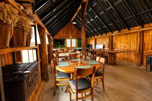 a dining room with a wooden table and chairs at Alma de campo - hospedagem para casais e famílias e amigos in Rio Rufino