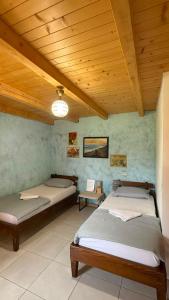 a room with three beds and a wooden ceiling at Balabani Local Stay in Podgorica