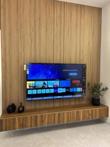 a large flat screen tv sitting on a wooden wall at Olive home in Al Khobar