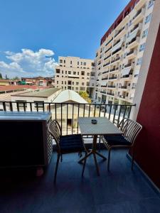 a balcony with a table and chairs and a building at Golden Space Apartment 3 in Tirana