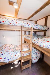 two bunk beds in a room with a ceiling at Ibiza Summer Lodge in Brouwershaven