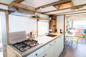 a kitchen with a stove top oven in a room at Ibiza Summer Lodge in Brouwershaven