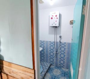 a bathroom with a shower with a toilet and a clock at Home Stay TB2 in Palayangan