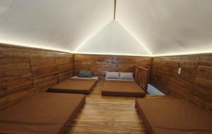 a room with three beds in a wooden room at Home Stay TB2 in Palayangan