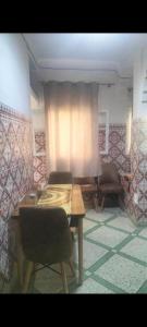 a room with a table and chairs and a curtain at Maison Bab boujloud in Fez