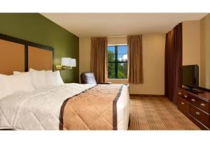 a hotel room with a bed and a television at Motel 6 Fairfield OH Cincinnati in Fairfield