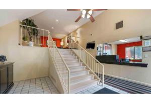 a staircase in a living room with a ceiling fan at Motel 6 Fairfield OH Cincinnati in Fairfield