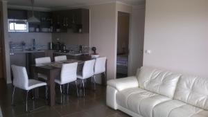 sala de estar con sofá y mesa con sillas blancas en Apartamentos Arenamaris, en Algarrobo