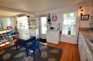 a kitchen with a table and a dining room at Berry Cottage, private dock, overlooking a sandy b in South Thomaston +24 photos