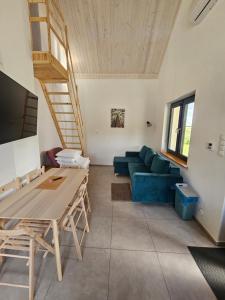 a living room with a blue couch and a table at Letnisko nad jeziorem in Skulsk