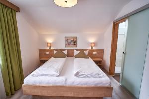 a bedroom with a bed and a green curtain at Appartements Pungg in Fügen +33 photos
