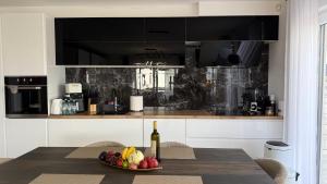 a kitchen with a table with a bowl of fruit and a bottle of wine at Apartment Istra Mare private pool & parking in Ližnjan +33 photos