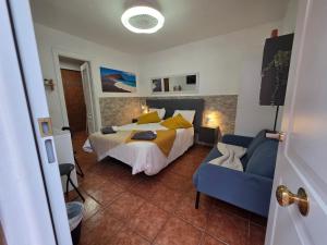 a bedroom with a bed and a blue couch at Alojamiento La Concha in Las Lagunas