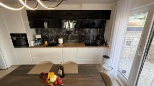 a kitchen with a table with a bowl of fruit on it at Apartment Istra Mare private pool & parking in Ližnjan