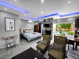 a bedroom with a bed and a table and chairs at Waterfall City Guest Lodge in Sandton +80 photos